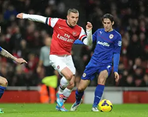 Arsenal V Cardiff City 2013-14 Prints: Arsenal's Lukas Podolski Faces Off Against Cardiff's Peter Whittingham in Premier League Clash