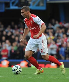 Chelsea v Arsenal 2014-15 Collection: Arsenal's Lukas Podolski Faces Off Against Chelsea at Stamford Bridge (2014-15 Premier League)