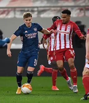 Arsenal's Martin Odegaard Clashes with Olympiacos Kenny Lala in UEFA Europa League Match Amidst Empty Stands