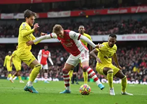 Arsenal's Martin Odegaard Faces Off Against Brentford's Mathias Jensen and Rico Henry in Intense Premier League Showdown