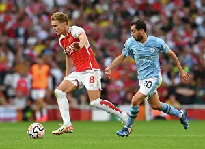 Arsenal's Martin Odegaard Faces Pressure from Manchester City's Bernardo Silva in 2023-24 Premier League Clash