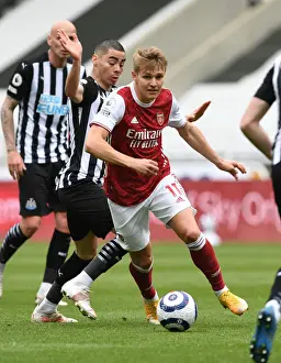 Arsenal's Martin Odegaard Outmaneuvers Newcastle's Miguel Almiron in Empty St. James Park