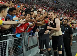 Arsenal V Singapore XI Prints: Arsenal's Per Mertesacker Celebrates with Fans after Arsenal's Victory over Singapore XI in Singapore