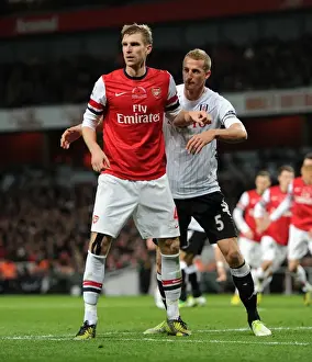 Arsenal's Mertesacker Clashes with Fulham's Hangeland in Premier League Showdown