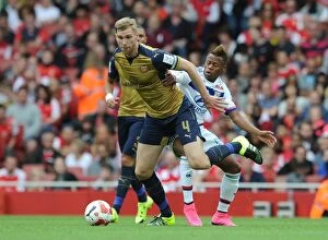 Arsenal v Olympique Lyonnais - Emirates Cup 2015/16 Collection: Arsenal's Per Mertesacker vs. Clinton N'Jie: A Tense Face-Off at the Emirates Cup