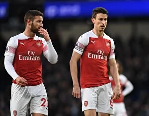 Manchester City v Arsenal 2018-19 Collection: Arsenal's Mustafi and Koscielny Face Off Against Manchester City in Premier League Clash (2018-19)