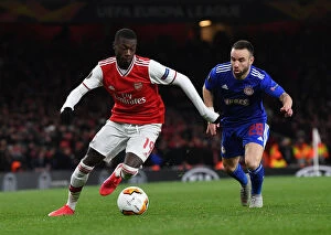 Images Dated 28th February 2020: Arsenal's Nicolas Pepe Clashes with Olympiacos Mathieu Vilbuena in Europa League Showdown