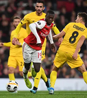 Arsenal's Nicolas Pepe Clashes with Standard Liege's Gojko Cimirot in Europa League Match
