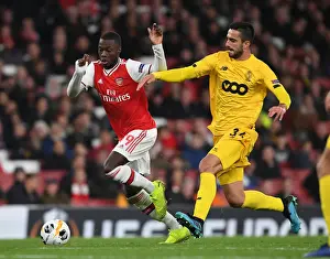 Arsenal's Nicolas Pepe Outmaneuvers Standard Liege's Kostas Laifis in UEFA Europa League Clash