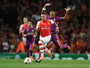 Arsenal V Galatasaray 2014/15 Champions League Prints: Arsenal's Oxlade-Chamberlain Clashes with Galatasaray's Felipe Melo in Champions League Showdown