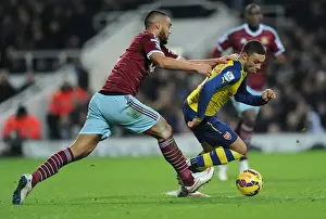West Ham United V Arsenal 2014-15 Prints: Arsenal's Oxlade-Chamberlain Outmaneuvers West Ham's Reid in Premier League Clash