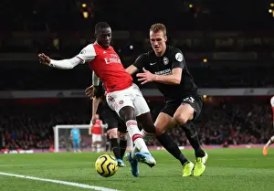 Arsenal's Pepe Faces Off Against Brighton's Burn in Premier League Clash