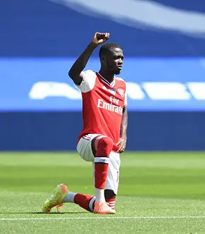 Brighton And Hove Albion V Arsenal 2019-20 Prints: Arsenal's Pepe Kneels at Empty Brighton Stadium - Premier League 2019-2020