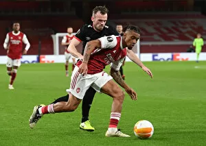 Images Dated 29th October 2020: Arsenal's Reiss Nelson Faces Off Against Dundalk's Cameron Dummigan in Empty Emirates Stadium
