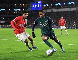 Images Dated 12th December 2023: Arsenal's Reiss Nelson Faces Off Against PSV's Malik Tillman in Champions League Clash