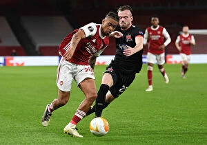 Images Dated 29th October 2020: Arsenal's Reiss Nelson Goes Head-to-Head with Dundalk's Cameron Dummigan in Empty Emirates Stadium