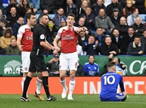 Leicester City v Arsenal 2018-19 Collection: Arsenal's Sokratis and Koscielny Protest Referee Decision in Leicester City vs Arsenal Premier