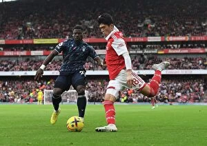 Arsenal v Nottingham Forest 2022-23 Collection: Arsenal's Tomiyasu Outmaneuvers Aurier in Premier League Clash vs. Nottingham Forest