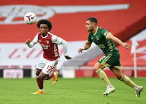 Arsenal's Willian Outmaneuvers Sheffield United's George Baldock in Empty Emirates Stadium