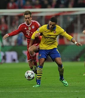 Images Dated 11th March 2014: Battle of the Midfield: Oxlade-Chamberlain vs. Lahm - Arsenal's Ox Takes on Bayern's Maestro in