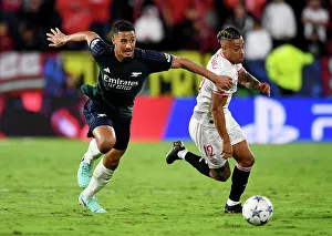 Battle for Possession: Sevilla vs. Arsenal - Arsenal's William Saliba Fights for the Ball against Mariano in the 2023/24 UEFA Champions League