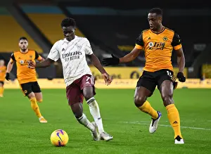Wolverhampton Wanderers V Arsenal 2020-21 Prints: Boly Holds Off Saka: Intense Battle at Molineux in Arsenal's Premier League Clash with Wolverhampton Wanderers
