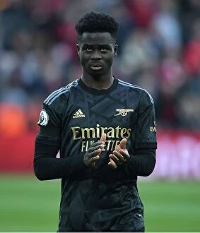 Liverpool v Arsenal 2022-23 Collection: Bukayo Saka Salutes Arsenal Fans: Triumphant Moment at Anfield After Intense Liverpool Clash