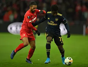 Standard Liege V Arsenal 2019-20 Prints: Bukayo Saka vs. Mehdi Carcela: A Europa League Battle at Standard Liege
