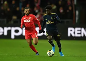 Standard Liege V Arsenal 2019-20 Prints: Bukayo Saka vs Mehdi Carcela: A Europa League Battle at Standard Liege