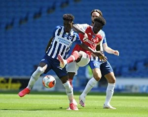 Brighton and Hove Albion v Arsenal 2019-20 Collection: Bukayo Saka vs. Yves Bissouma: A Battle in the Empty Arsenal Stadium