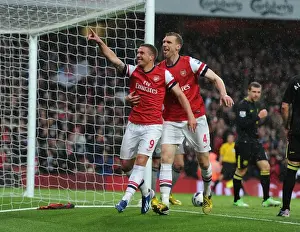 Arsenal V Wigan Athletic 2012-13 Prints: Celebrating Glory: Podolski and Mertesacker's Goal Bliss (Arsenal vs Wigan Athletic)