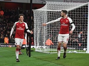 Arsenal v Huddersfield Town 2017-18 Collection: Celebrating Goal: Ozil and Ramsey Rejoice After Sanchez's Strike in Arsenal's Victory vs
