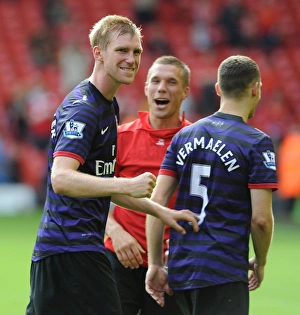 Celebrating Victory: Per Mertesacker, Lukas Podolski, and Thomas Vermaelen of Arsenal
