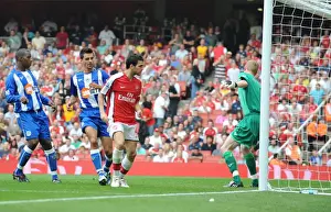 Cesc Fabregas shoots past Wigan goalkeeper Chris Kirkland