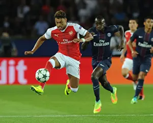 Paris Saint Gernain V Arsenal 2016-17 Prints: Champions League Showdown: Oxlade-Chamberlain's Battle at Parc des Princes - Paris Saint-Germain vs