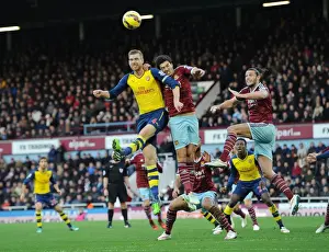 West Ham United V Arsenal 2014-15 Prints: Clash at the Boleyn: Mertesacker Faces Off Against Carroll and Tomkins