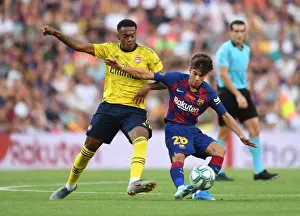 Clash at the Camp: Arsenal's Joe Willock Tackles Riqui Puig in FC Barcelona vs Arsenal Pre-Season Friendly
