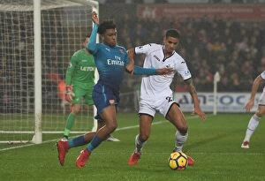 Swansea City v Arsenal 2017-18 Collection: Clash at Liberty: Iwobi vs. Naughton - A Football Rivalry Unfolds