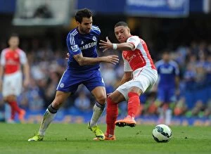 Chelsea v Arsenal 2014-15 Collection: Clash of the Midfield Maestros: Oxlade-Chamberlain vs. Fabregas - A Premier League Battle