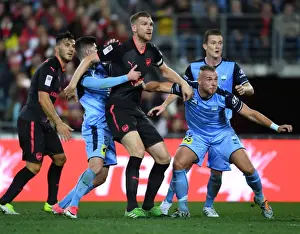 Sydney FC V Arsenal - 2017-18 Prints: Clash in Sydney: Per Mertesacker Faces Off Against Paulo Retre and Jordy Bujis of Sydney FC
