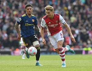 Images Dated 23rd April 2022: Clash of Talents: Arsenal's Martin Odegaard vs Manchester United's Jadon Sancho in the Premier
