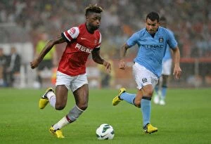 Images Dated 27th July 2012: Clash of Titans: Alex Song vs. Carlos Tevez - Arsenal FC vs. Manchester City, Beijing 2012