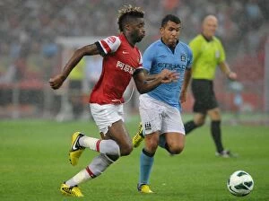 Images Dated 27th July 2012: Clash of Titans: Alex Song vs. Carlos Tevez - Arsenal FC vs. Manchester City