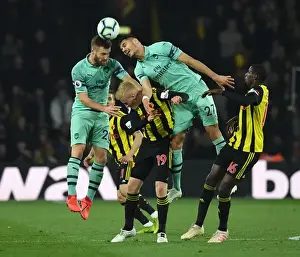 Clash at Vicarage Road: Mustafi and Mavropanos Go Head-to-Head Against Watford's Hughes