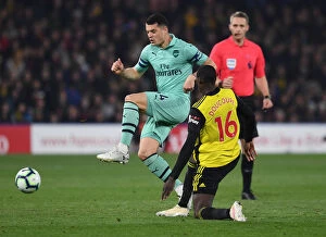 Watford v Arsenal 2018-19 Collection: Clash at Vicarage Road: Xhaka vs. Doucoure in the Premier League Battle between Watford and Arsenal