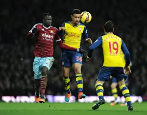 West Ham United V Arsenal 2014-15 Prints: Coquelin vs. Kouyate: Intense Heading Battle Between Arsenal's Midfield Duo and West Ham's Defender