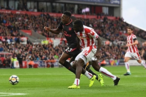 Stoke City v Arsenal 2017-18 Collection: Danny Welbeck (Arsenal) Mame Diouf (Stoke). Stoke City 1: 0 Arsenal. Premier League