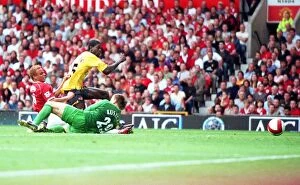 Manchester United v Arsenal 2006-7 Collection: Emmanuel Adebayor shoots past Manchester United goalkeeper Tomaz Kuszczak to score the Arsenal goal