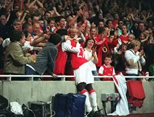 Emmanuel Eboue celebrates with the fans after Thierry Henrys goal for Arsenal
