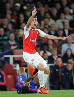Arsenal V Olympiacos 2015/16 Prints: Gabriel's Defiant Clash: Arsenal vs Olympiacos in the 2015/16 UEFA Champions League